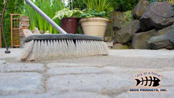 A close up image of a broom sweeping dirt