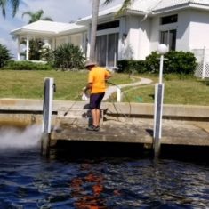 a worker pressure washing a dock